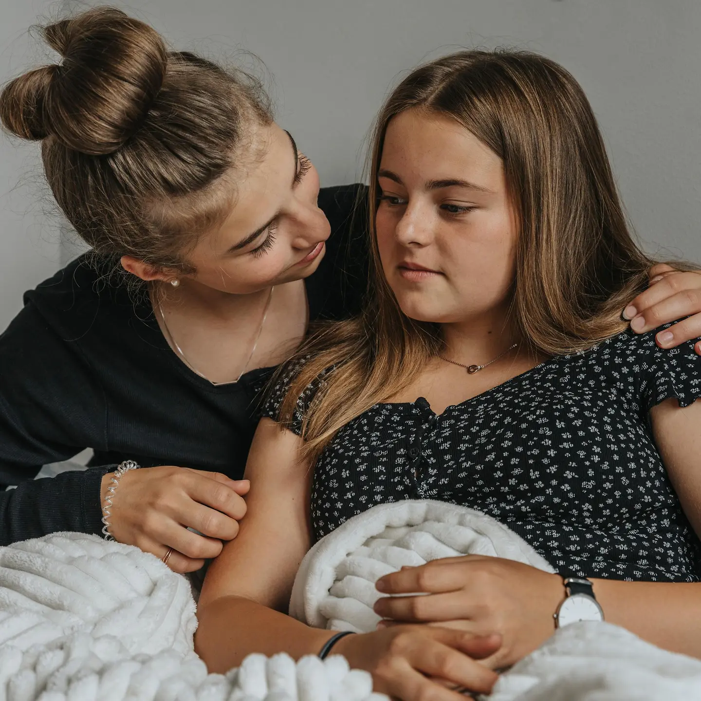 Ein Mädchen legt den Arm um die Schulter eines anderen Mädchens